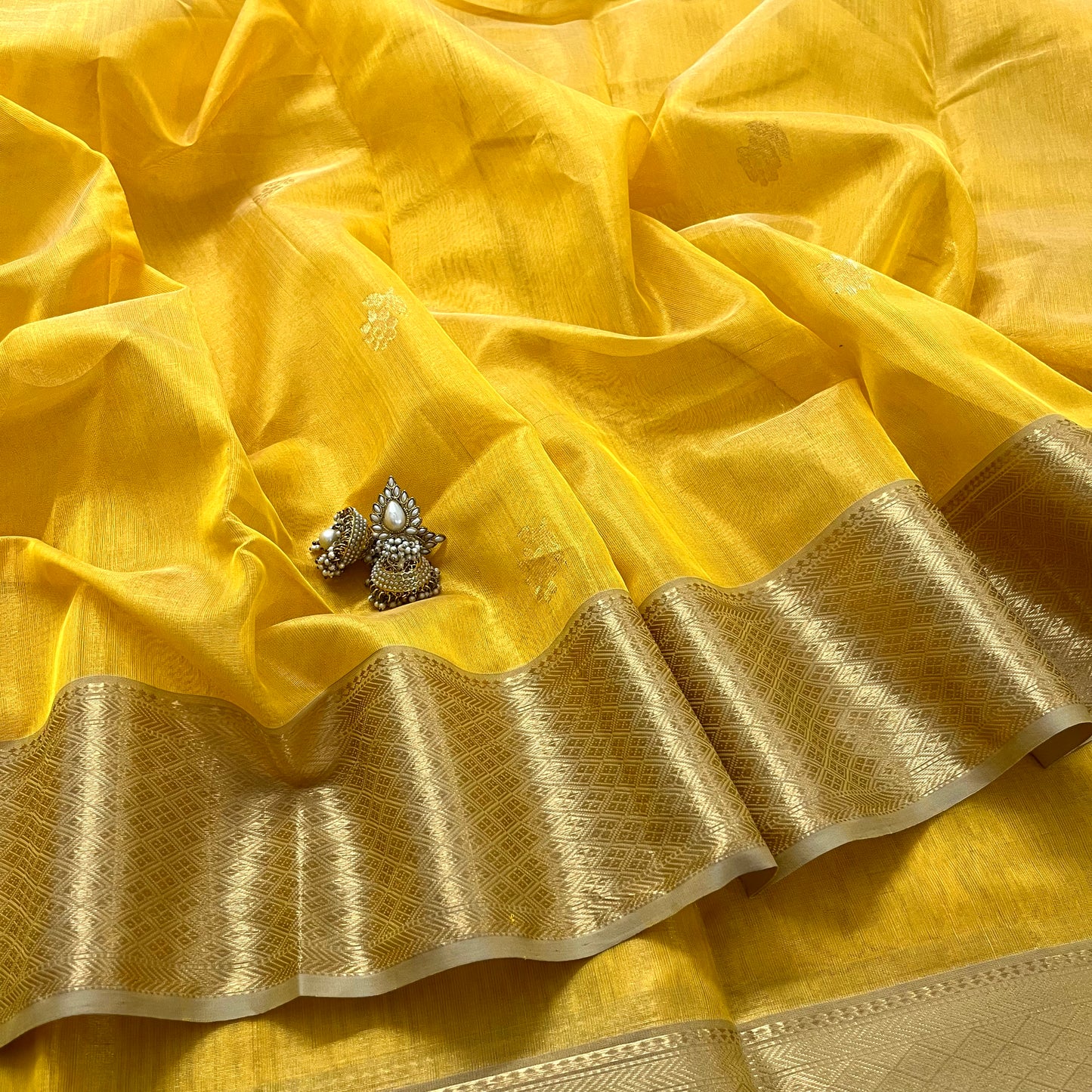 Yellow maheshwari tissue silk saree with flower motifs all over