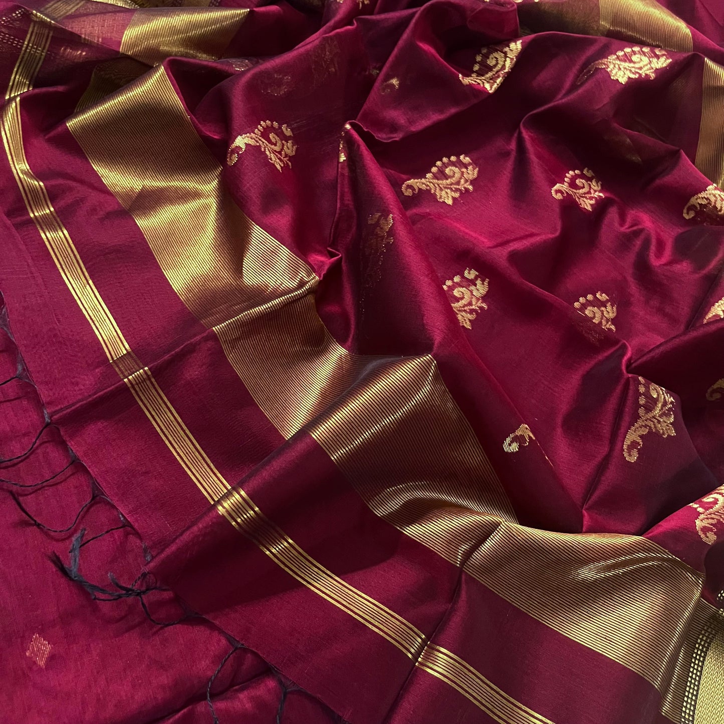 Deep maroon Maheshwari saree with zari motifs on pallu