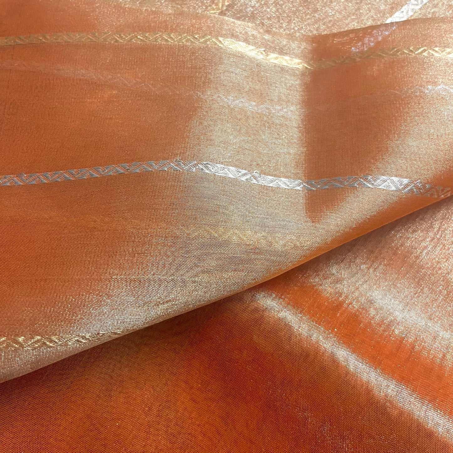 Rust orange banarasi tissue silk saree with zari bootis and zari border