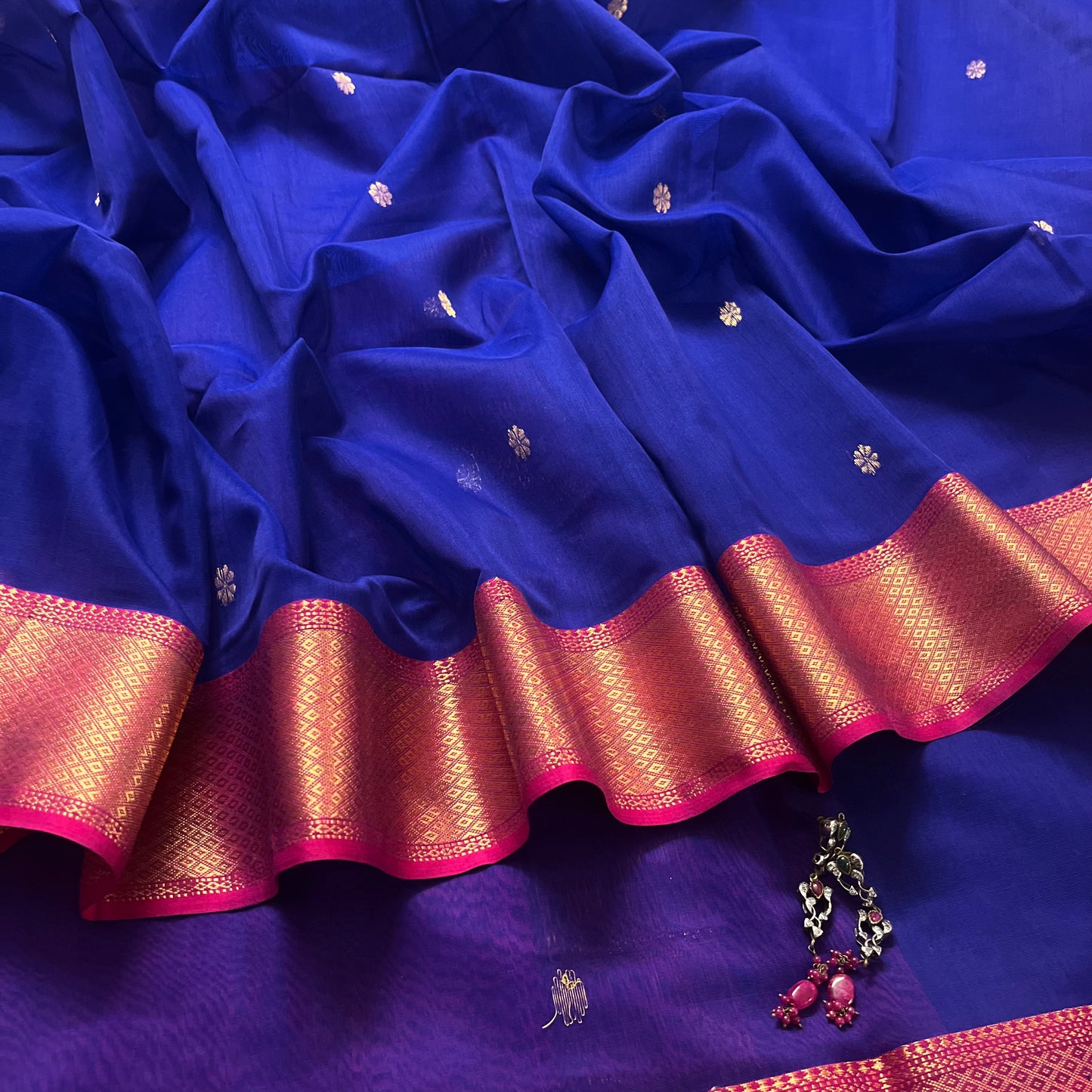 Dark blue and pink maheshwari saree with flower motifs on pallu