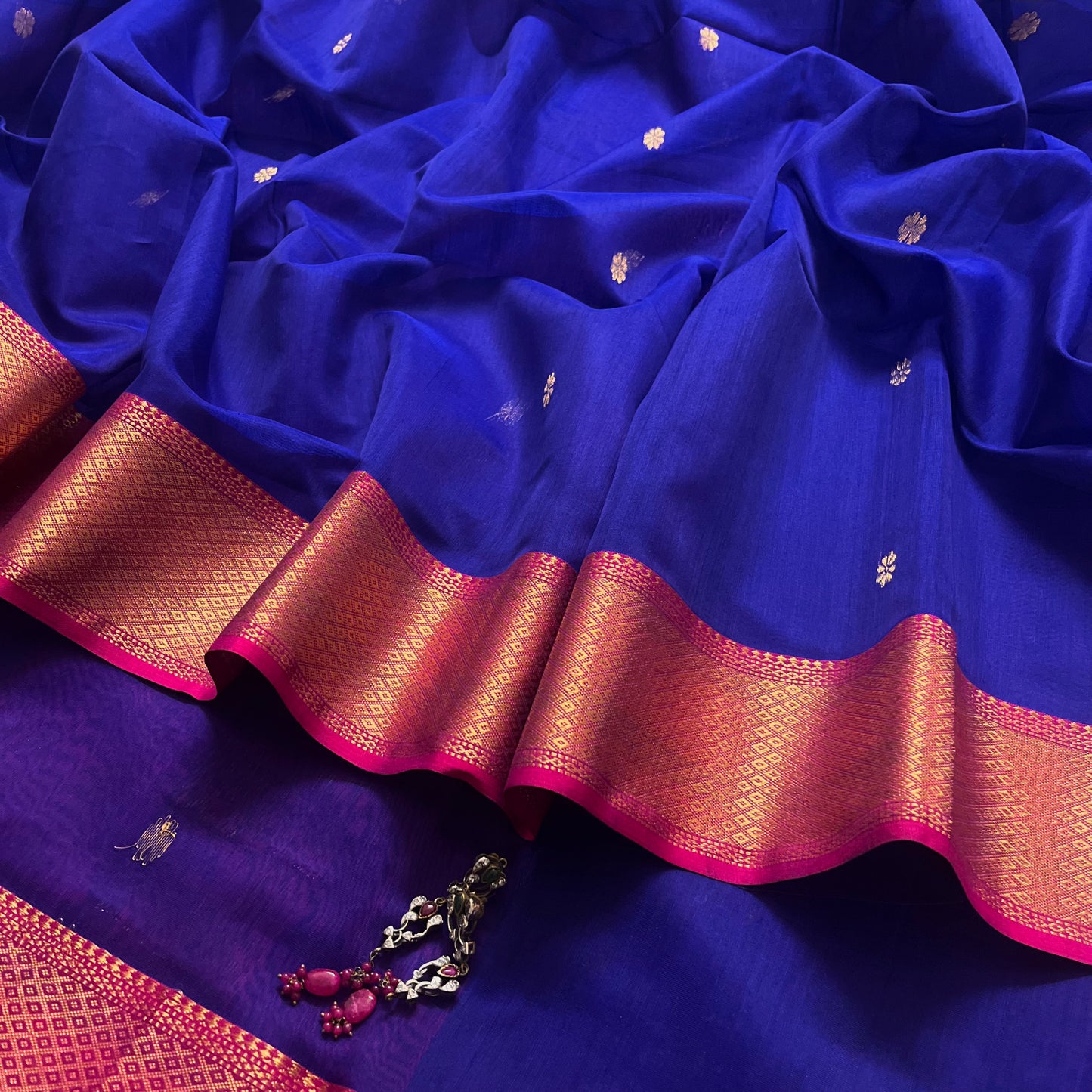 Dark blue and pink maheshwari saree with flower motifs on pallu